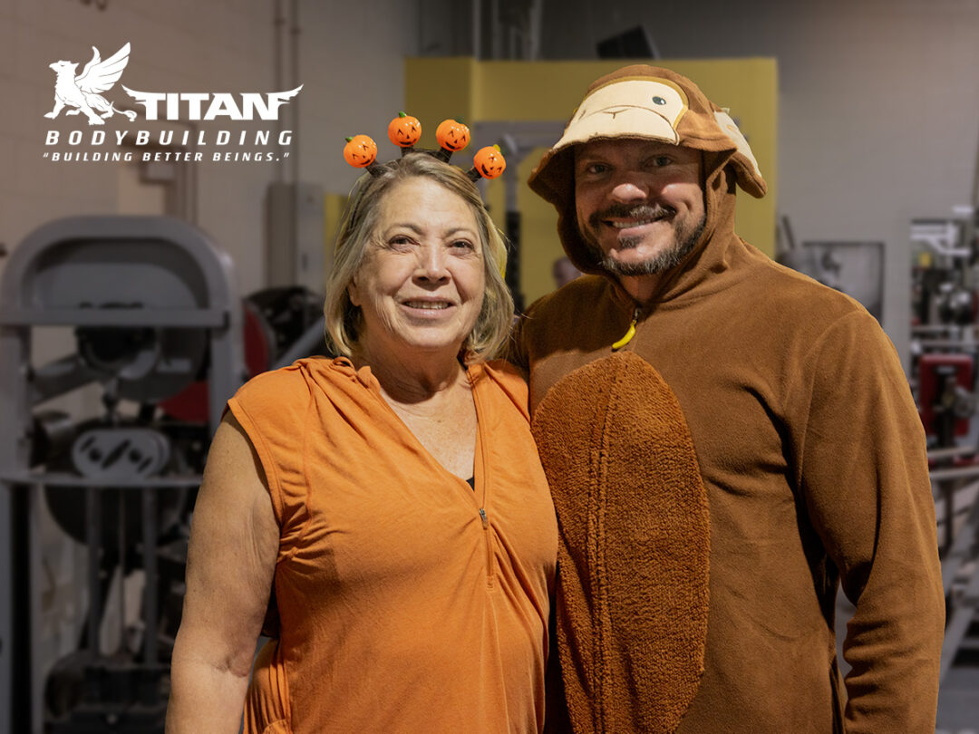 Joel Griffin, lead trainer with Titan Bodybuilding, in a Donkey Kong onesie with one of his long-term jack-o-lantern clad Lifestyle clients.